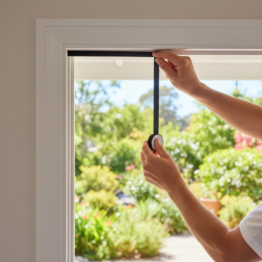 Pressing the hook-and-loop strip onto the door frame